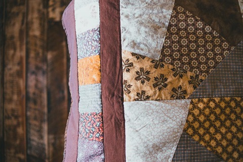 colourful patterned fabric patches hand sewn into beautiful quilt for bed