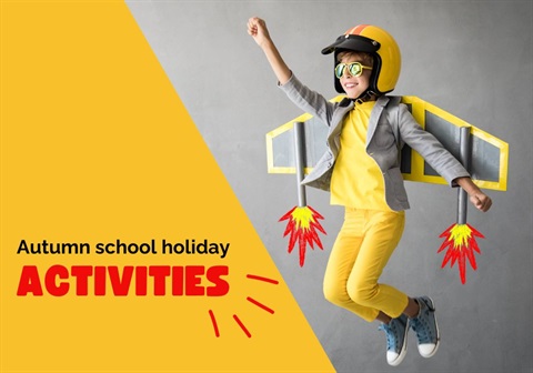 Child dressed up as a rocket, with cardboard wings and a yellow jumpsuit and yellow helmet. With fist in the air to imitate flying. Text reads Autumn school holiday activities