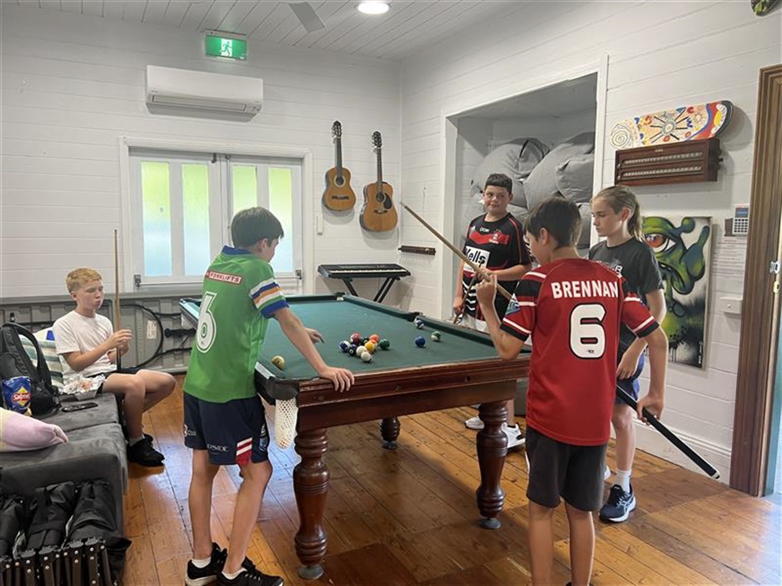 Young youth playing pool on pool table at youth centre